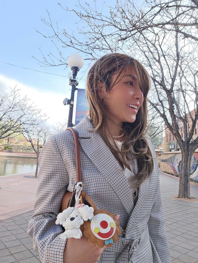Dog leather bag charm attached to a handbag