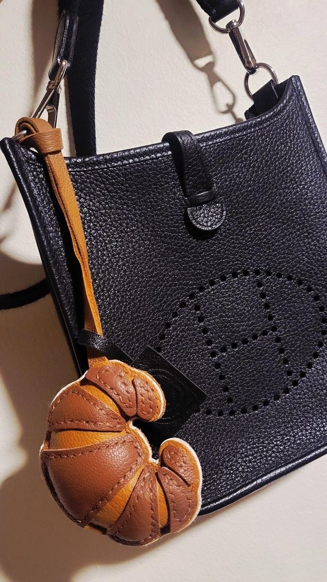 Customer making a confident purchase decision after comparing leather bag charms