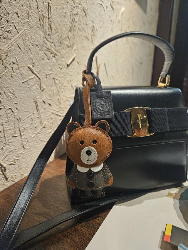 New handcrafted leather bag charm attached to a handbag during its first week of use