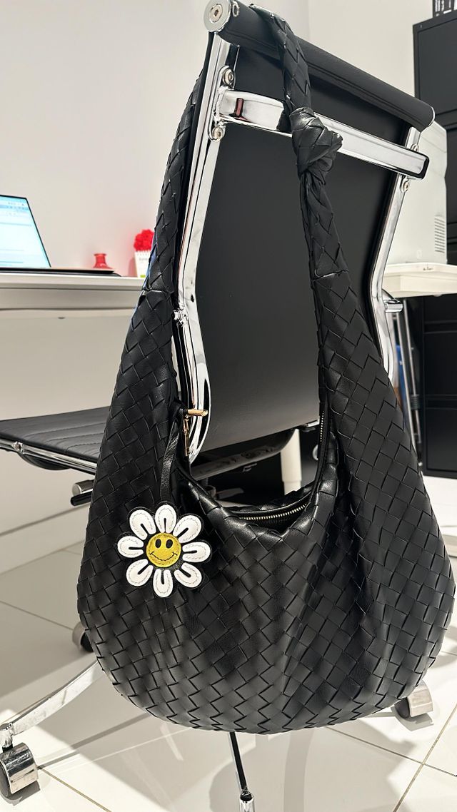 Woman carrying a leather handbag with a handcrafted leather charm during everyday life